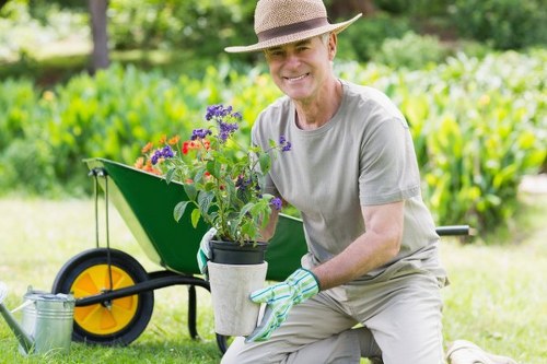 Worker wearing protective equipment operating garden machinery